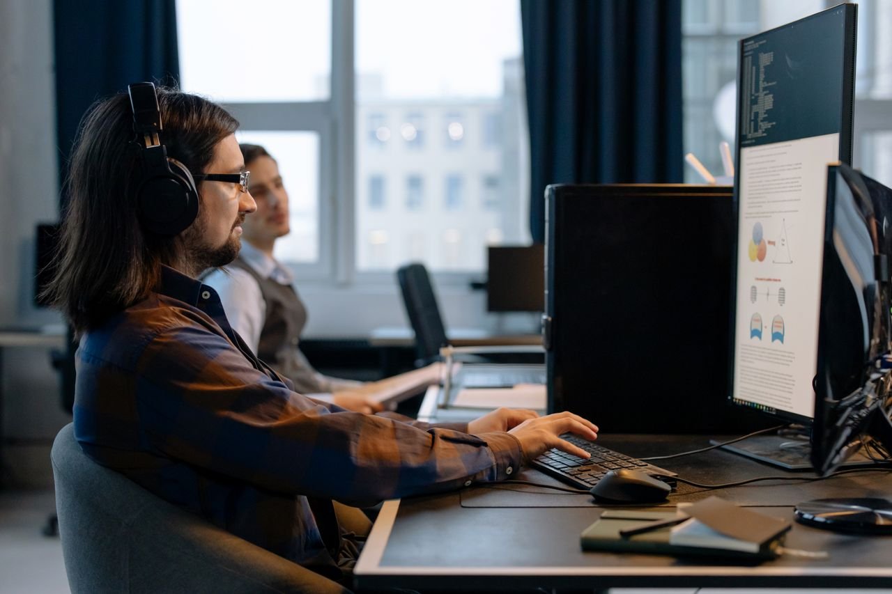 Two programmers working together with focus on coding in a modern, tech-savvy office environment.